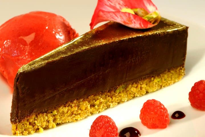 Gold-dusted chocolate tart with berry sorbet and fresh raspberries