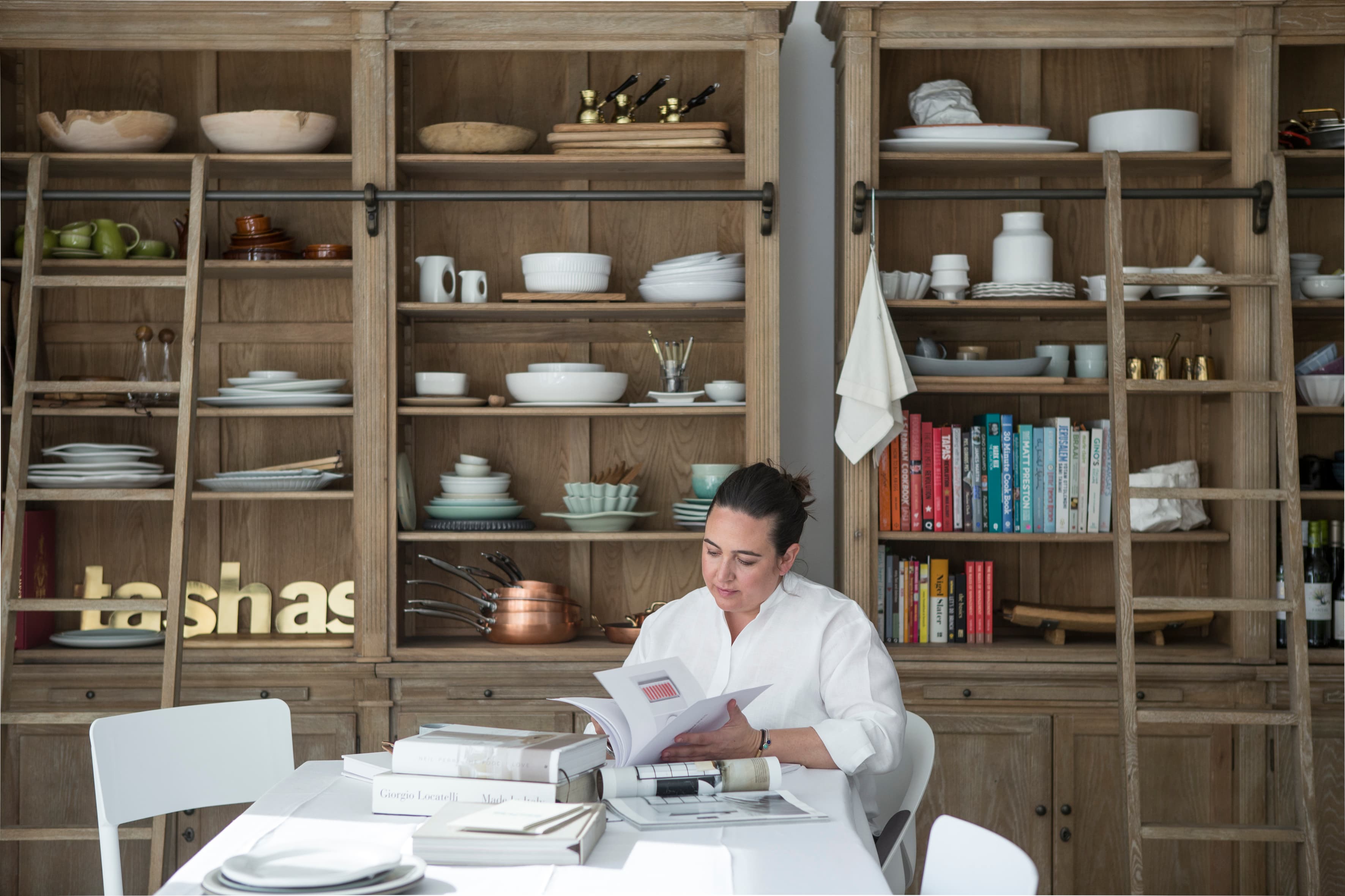 The tashas kitchen library — rustic shelving, white ceramics and cookbooks